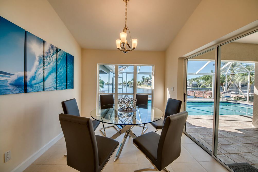 Essbereich mit rundem Glastisch und Ausblick auf die Terrasse in der Villa Blue Pearl in Cape Coral, Florida