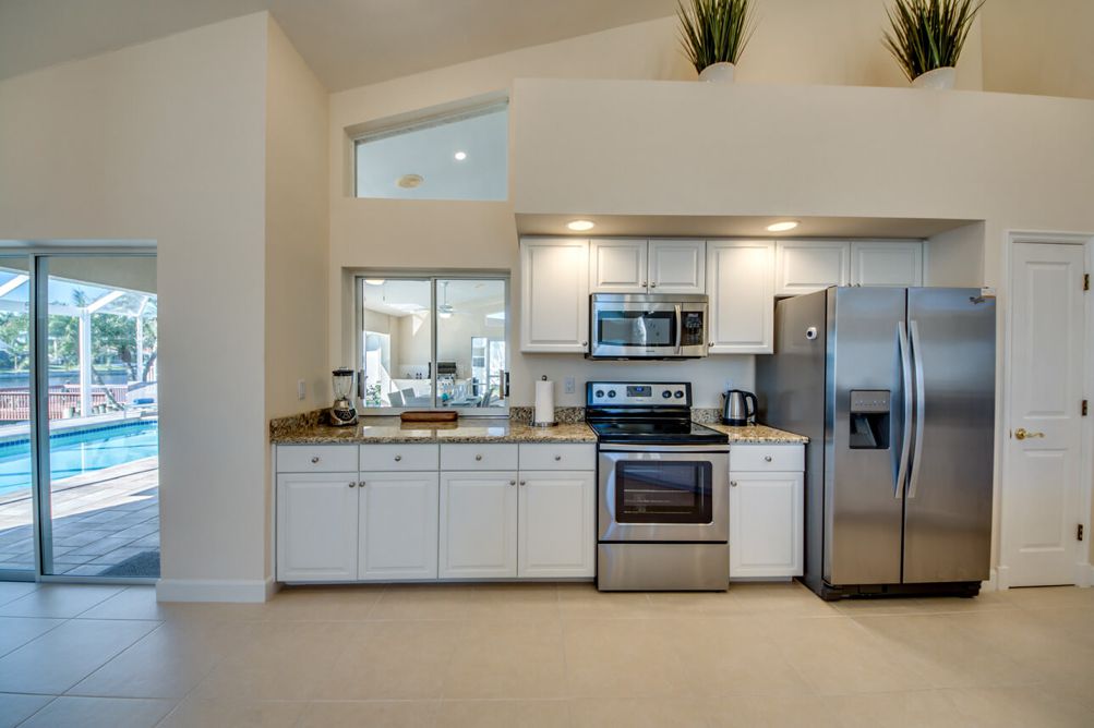 Küche mit weißen Küchenfronten und Kühlschrank mit Doppeltür in der Villa Blue Pearl in Cape Coral, Florida