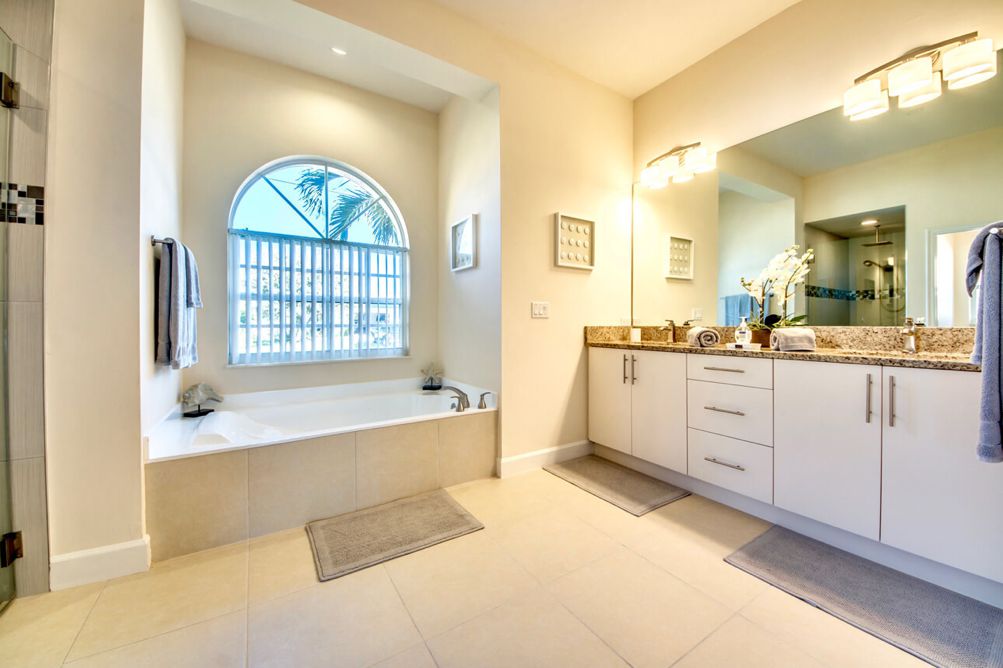 Hauptbadezimmer mit Badewanne und 2 Waschbecken mit Unterschränken in der Villa Blue Pearl in Cape Coral, Florida