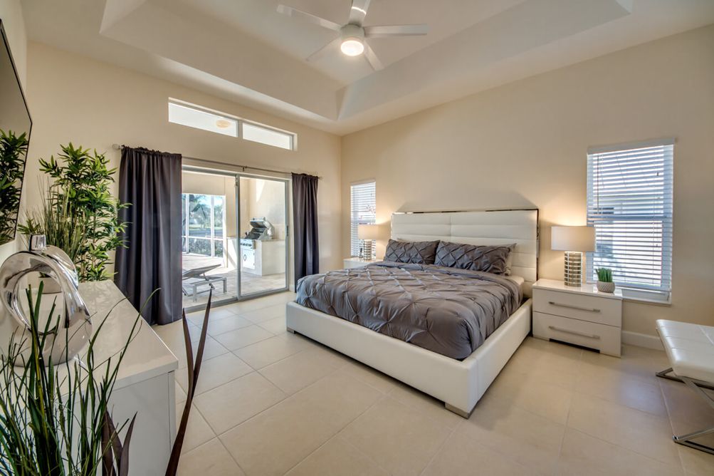 Hauptschlafzimmer mit weißen Möbeln und großem Doppelbett in der Villa Blue Pearl in Cape Coral, Florida