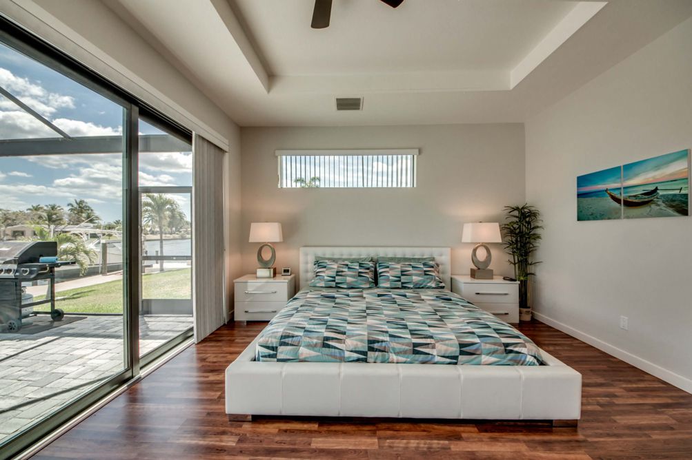 Drittes Schlafzimmer mit Kingbett und Zugang zur Terrasse in der Villa Carpe Diem in Cape Coral, Florida