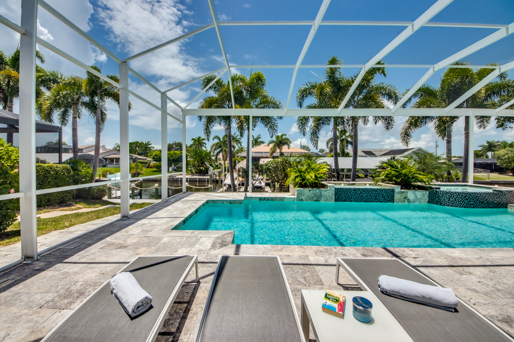 Drei Sonnenliegen vor dem Pool der Villa Perfect Life