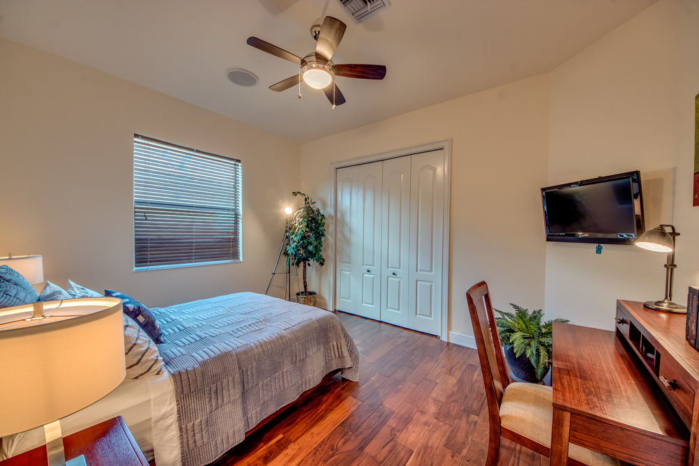 Schlafzimmer mit Schreibtisch und Holzboden in der Villa Regency in Cape Coral, Florida