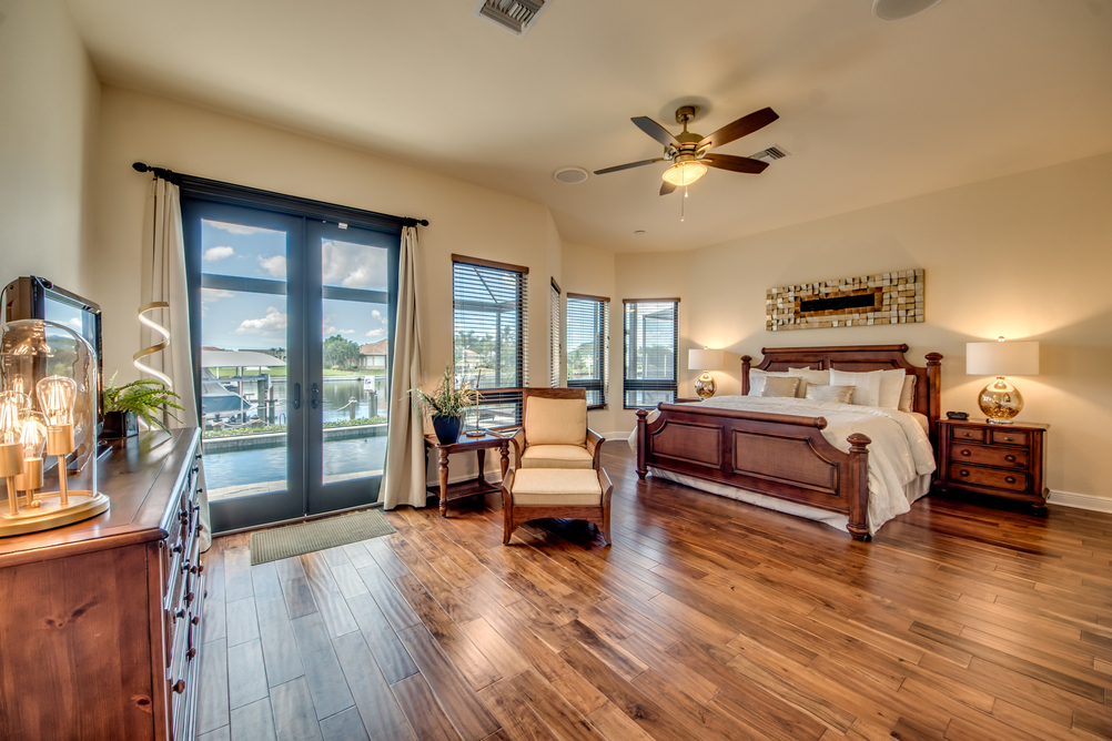 Großzügiges Schlafzimmer mit Holzmöbeln und Holdboden in der Villa Regency in Cape Coral, Florida