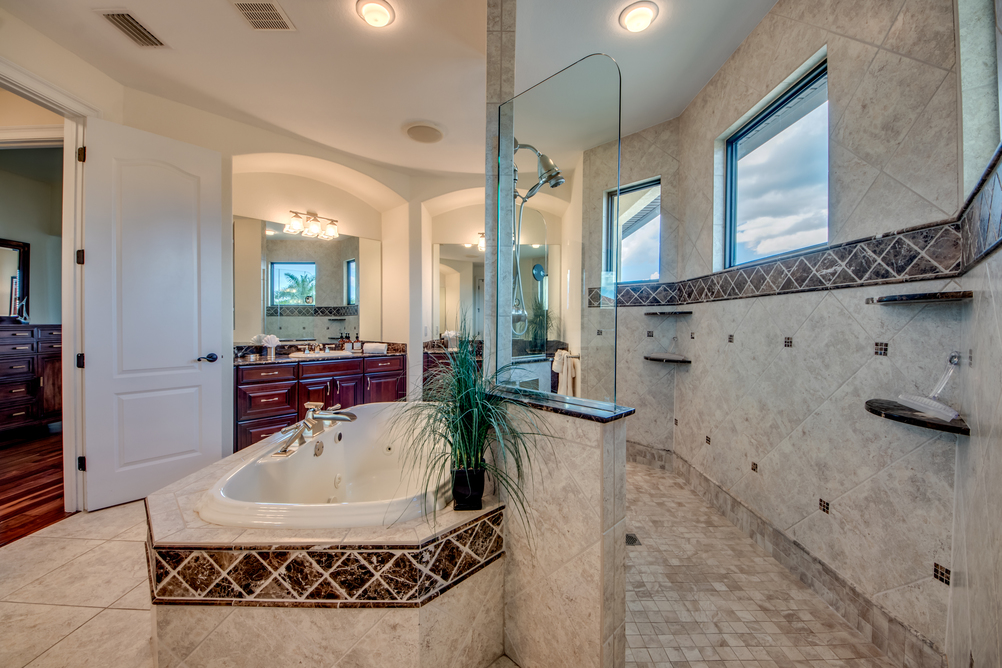 Zur Seite hin offene Dusche mit angrenzendem Jacuzzi im Hauptbadezimmer der Villa Regency in Cape Coral, Florida