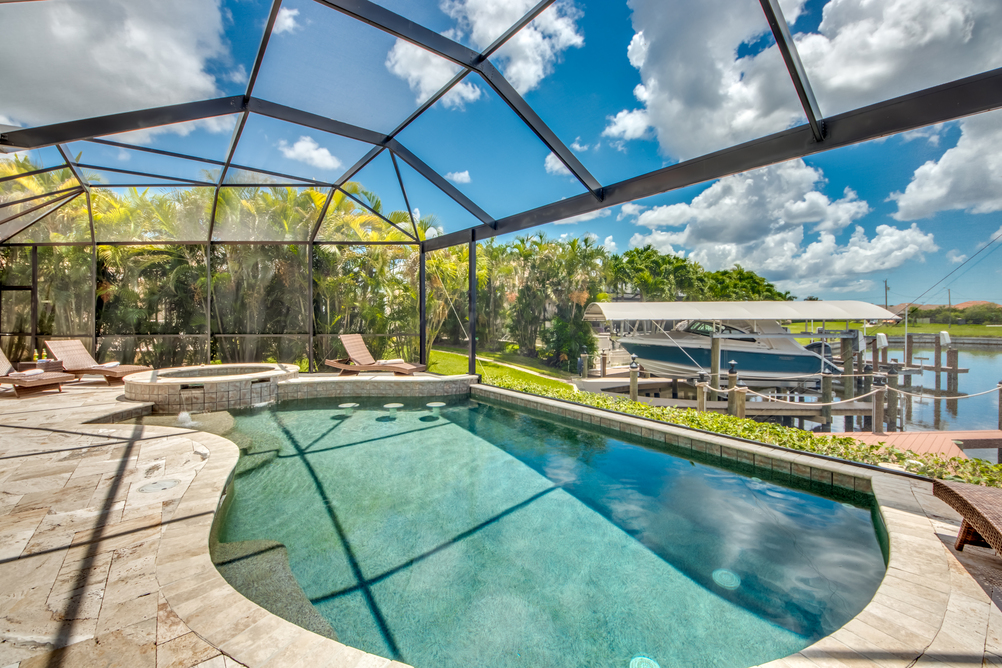 Poolbereich mit angrenzendem Außenbereich und Anlegesteg in der Villa Regency in Cape Coral, Florida