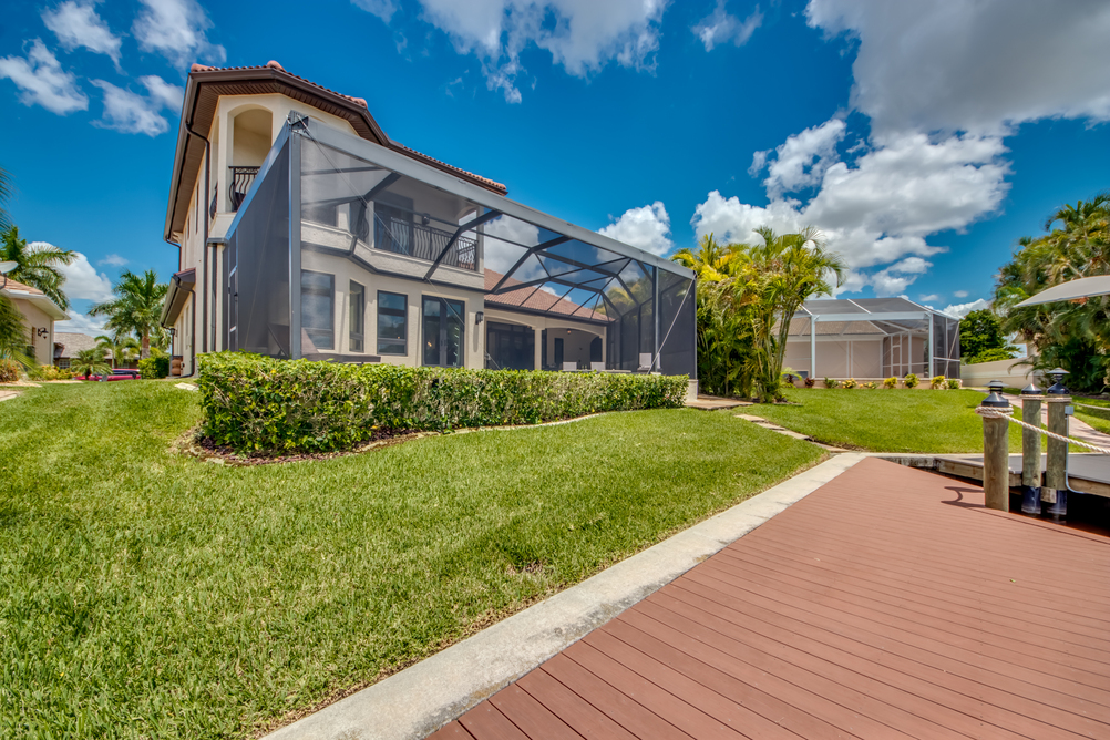 Blick vom Garten auf die Villa und den überdachten Poolbereich in der Villa Regency in Cape Coral, Florida