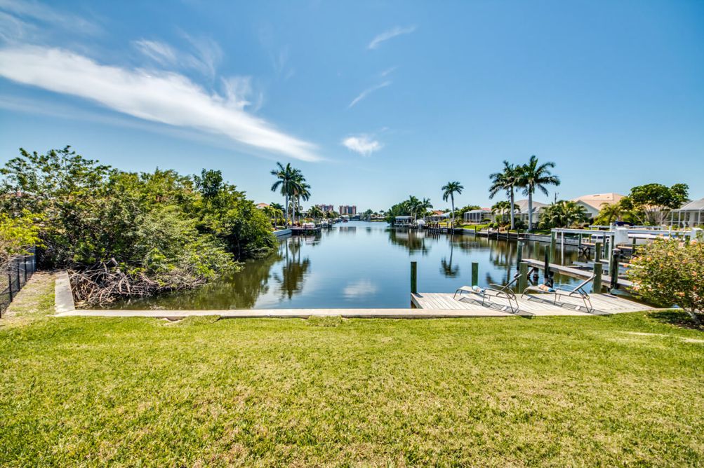 Steg mit Sonnenliegen am Kanal hinter der Villa Sunshine Bay