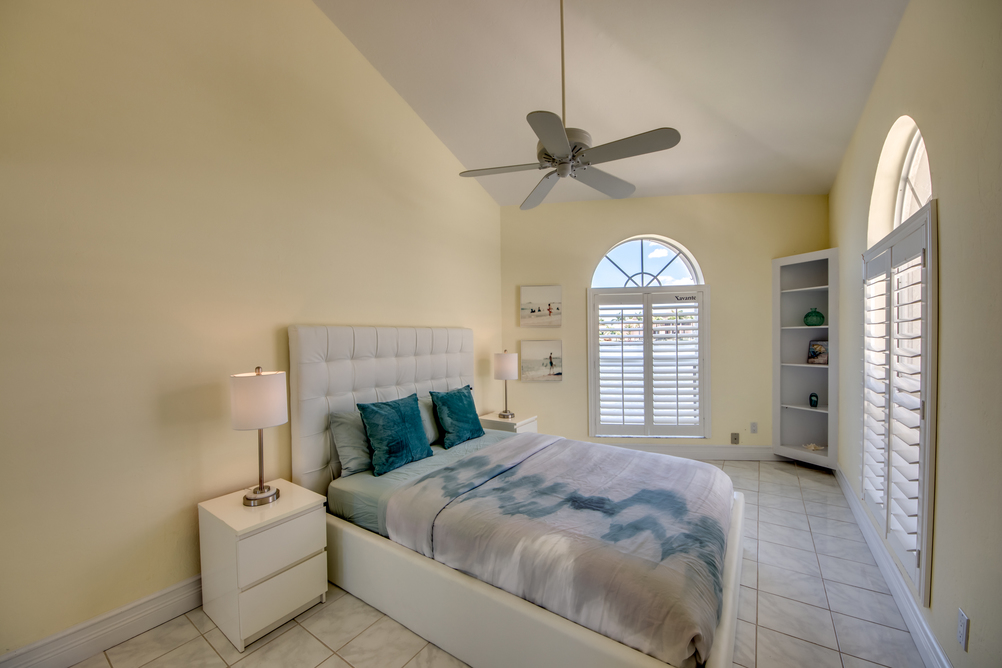 Schlafzimmer mit weißen Möbeln und blauer Bettwäsche in der Villa Superior