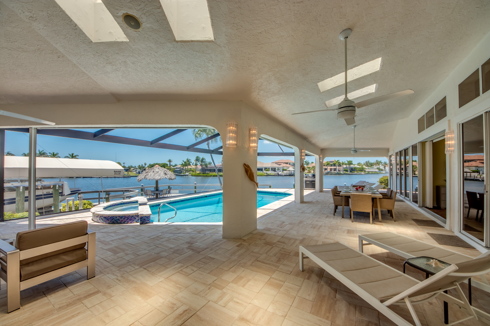 Ausblick auf den Pool, Esstisch und Liegen aus der Villa Superior